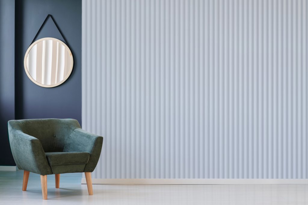Green,Armchair,Against,Blue,Wall,With,Round,Mirror,In,Living